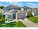 Charming two-story home featuring a well-manicured lawn, inviting curb appeal, and an attached two-car garage at 965 Maypole Dr, Apopka, FL 32703