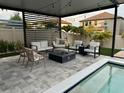 Stylish outdoor lounge area under a pergola, featuring comfortable seating, a fire pit, and a view of the pool at 9863 Summerlake Groves St, Winter Garden, FL 34787