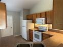 Efficient kitchen boasting classic cabinets, appliances, and ample counter space with tiled floor at 9923 Dean Acre Dr, Orlando, FL 32825