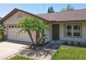 Close-up of the front of the home with a two-car garage, an entryway, and landscaping at 10018 Chesham Dr, Orlando, FL 32817