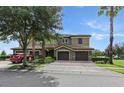 Beautiful two-story home with a well-manicured lawn, mature trees, and brick paved driveway at 1269 Long Cove Loop # 1269, Davenport, FL 33896