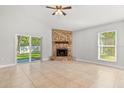 Bright living area with tiled floors, a stone fireplace, and sliding glass door access to the backyard at 1346 Palo Alto Ct, Winter Springs, FL 32708