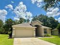 Charming one-story home features a well-maintained lawn and a two-car garage at 14715 Buckingham Gate Ct, Orlando, FL 32828