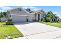 Charming single-Gathering home featuring a well-maintained lawn and a spacious driveway leading to a three-car garage at 17290 Hickory Wind Dr, Clermont, FL 34711