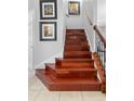 Elegant staircase with hardwood steps, complemented by wrought iron spindles and a wooden handrail at 1785 Rushden Dr, Ocoee, FL 34761