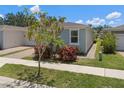 Well-maintained home with lush lawn, complemented by mature trees and colorful foliage at 1841 Overcup Ave, St Cloud, FL 34769