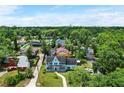Aerial view of a blue two-story home surrounded by lush greenery in a residential neighborhood at 201 Garden Ln, Longwood, FL 32750