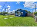 This blue home has a grassy lawn and a white trimmed front door at 205 9Th St, St Cloud, FL 34769