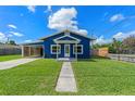 Inviting blue home featuring a well-manicured lawn and cozy covered front porch at 205 9Th St, St Cloud, FL 34769