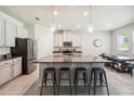 Spacious kitchen with stainless steel appliances, a granite island with barstool seating, and an adjacent dining area at 3142 Hill Point St, Minneola, FL 34715