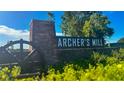 Stone community entrance sign, 'Archer's Mill', against a backdrop of lush landscaping, blue sky and green trees at 3337 Arch Ave, Ormond Beach, FL 32174