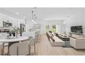 Open concept living room connected to a modern kitchen, featuring ample seating and natural light at 4572 Sw 149Th St, Ocala, FL 34473