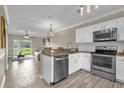 Modern kitchen with stainless steel appliances and granite countertops with an open view to the living room at 517 Wilton Cir, Sanford, FL 32773