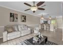 Cozy living room showcasing open layout to kitchen with tile floors and neutral paint at 517 Wilton Cir, Sanford, FL 32773