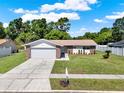 Attractive single-story home with large driveway, lush lawn, and charming curb appeal at 5210 Poinsetta Ave, Winter Park, FL 32792