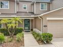 The front entrance of the townhome features well-manicured landscaping, leading up to a green front door at 533 Mount Olympus Blvd, New Smyrna Beach, FL 32168