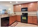 The kitchen features wooden cabinets, granite countertops, a black dishwasher, oven, and microwave at 533 Mount Olympus Blvd, New Smyrna Beach, FL 32168