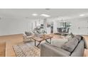 Open-concept living room with modern furnishings, light wood floors and a large kitchen at 5460 Se 28Th St, Ocala, FL 34480