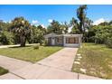 Single-story home featuring gray stucco, a well-kept lawn, and mature trees at 600 Plum Ln, Altamonte Springs, FL 32701