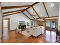 Spacious living room with vaulted ceilings, wood beams, fireplace, and access to the outdoor pool area at 8665 Vista Point Cv, Orlando, FL 32836