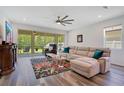Cozy living room with a large sofa, colorful rug, and view of the outdoor screened patio at 9426 Launch Point Rd, Orlando, FL 32832