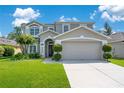 Charming two-story house with a wide driveway, attached garage and well-maintained front lawn and garden at 9846 Palmetto Dunes Ct, Orlando, FL 32832
