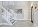 Bright foyer with a staircase, tile floors, and contemporary artwork at 9846 Palmetto Dunes Ct, Orlando, FL 32832