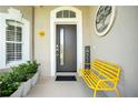 Welcoming front porch with a modern door, stylish decor, and a bright yellow bench at 9846 Palmetto Dunes Ct, Orlando, FL 32832