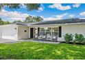 Inviting single-story home with a black front door and rocking chairs adding charm to the brick-paved front porch at 2114 Geigel Ct, Orlando, FL 32806