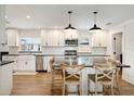 Modern kitchen with white cabinets, subway tile backsplash, a farmhouse sink, and a large island with seating at 2114 Geigel Ct, Orlando, FL 32806
