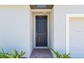 Close-up of the attractive front door, set back in an alcove, with a red brick walk and foundation plants at 2365 White Tail St, Davenport, FL 33837