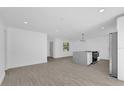 Bright, open-concept living space with neutral flooring, recessed lighting, and white walls at 2601 Telstar Ave, Orlando, FL 32805