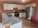 Updated kitchen featuring stainless steel appliances, granite counters, and white cabinets at 3013 Barrymore Ct, Orlando, FL 32835