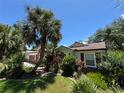Inviting single-story home with mature palms and lush tropical landscaping at 3807 Plantation Blvd, Leesburg, FL 34748