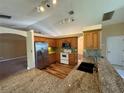 Bright kitchen featuring granite countertops, wood cabinets and stainless steel appliances at 3807 Plantation Blvd, Leesburg, FL 34748