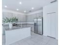 Bright, open kitchen with granite countertops, stainless steel appliances, and tile flooring at 4266 Wrangler Ln, Mascotte, FL 34753