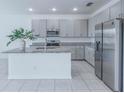 Bright, open kitchen with granite countertops, stainless steel appliances, and tile flooring at 4266 Wrangler Ln, Mascotte, FL 34753