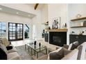 Open-concept living room with fireplace, high ceilings, wood beams, and black framed windows at 4343 Juliana Lake Dr, Auburndale, FL 33823