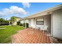 Inviting front porch with brick tiling, offering a cozy outdoor seating area and view of the landscaped yard at 4629 Spottswood Dr, Orlando, FL 32812