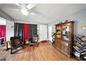 Cozy living room featuring hardwood floors, comfortable seating, and a cabinet with books and decorative items at 4629 Spottswood Dr, Orlando, FL 32812