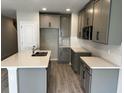 Bright, open kitchen with gray cabinets, stainless steel microwave, subway tile, and a large island with a sink at 5101 Prairie Preserve Run, St Cloud, FL 34772