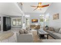 Bright living room with high ceilings, a ceiling fan, multiple windows, and two sofas with a staircase nearby at 5365 Rocking Horse Pl, Oviedo, FL 32765