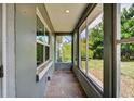 This view of the enclosed porch showcases tiled floors, natural light, and beautiful outdoor scenery at 540 W Columbia St, Lake Alfred, FL 33850