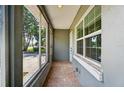 Enclosed porch with large windows providing natural light and views, tiled floors, and access to the front door at 540 W Columbia St, Lake Alfred, FL 33850