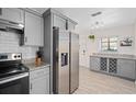 Updated kitchen showcasing stainless steel refrigerator, granite counters, white subway tile and wine rack storage at 5420 Lido St, Orlando, FL 32807