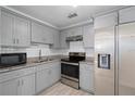 Modern kitchen featuring gray cabinets, granite countertops, stainless steel appliances and white subway tile backsplash at 5420 Lido St, Orlando, FL 32807