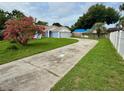 Picture of house with light blue trim and long drive way with mature pink tree at 6026 Canyon De Chelley Ct, Orlando, FL 32810
