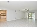 Large living area featuring tile flooring, ceiling fan, sliders to patio and open kitchen at 7104 Olympia Ct # 7104, Longwood, FL 32779