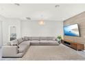 Spacious living room with a comfortable sectional sofa and a modern media center at 8713 Iron Mountain Trl, Windermere, FL 34786