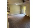Spacious living room featuring neutral carpet, adjacent dining nook and sliding glass doors at 120 Hibiscus Woods Ct # 11B, Deltona, FL 32725
